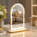 Decorative vanity mirror with LED lighting on a marble surface, surrounded by decorative items.